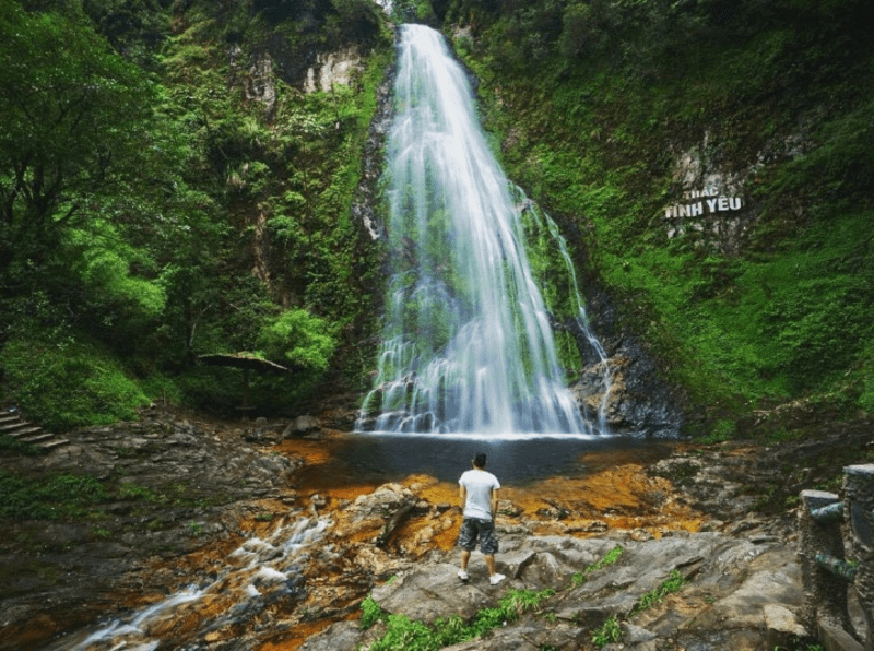 Một biển báo cảnh báo trơn trượt trên đường đi lát đá ở Núi Hàm Rồng, có người đang đi cẩn thận